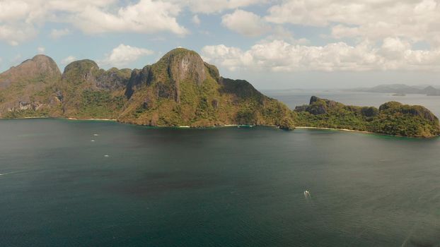 Seascape with tropical rocky islands, ocean blue water, aerial view . islands and mountains covered with tropical forest. El nido, Philippines, Palawan. Tropical Mountain Range