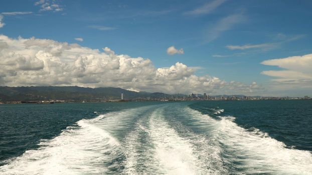 Water trace formed from powerful speed ferry engines, cruising at high speed. Trail on sea surface behind of speed boats. Water trail foaming behind a ferry. Travel concept.