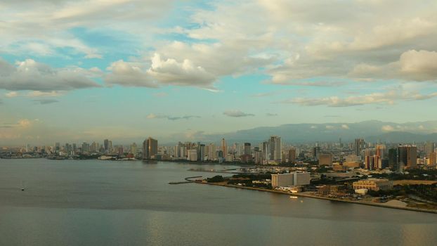 Skyscrapers and business centers in a big city Manila. Modern metropolis at sunset, top view.