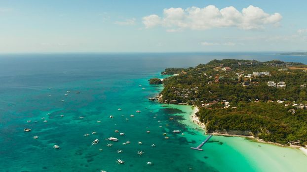 Sandy beach and turquoise water in the tropical resort of Boracay, Philippines. White beach with tourists and hotels. Summer and travel vacation concept.