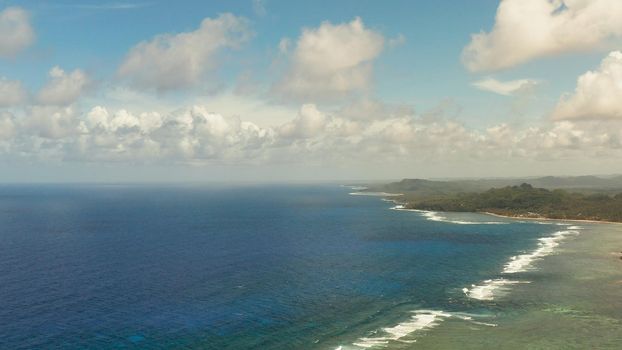 Tropical island with forest and ocean with surf and coral reef top view. Summer and travel vacation concept