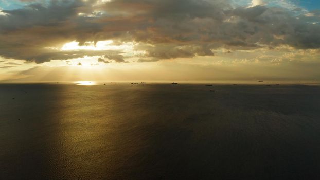 Dramatic sunset over Manila Bay with ships and cargo ships, top view. Summer and travel vacation concept