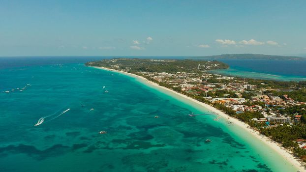 Tropical lagoon with turquoise water and white sand beach from above. Boracay, Philippines. White beach with tourists and hotels. Summer and travel vacation concept.
