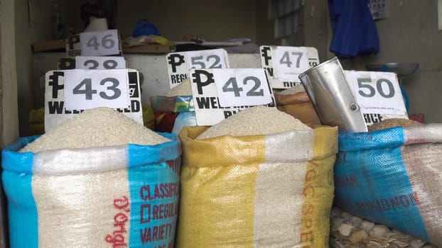 Rice for sale at the asian market. Various bags of rice in a local outdoor market with price. Philippines.