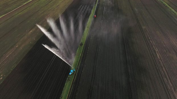 Irrigation equipment watering freshly seeded field.Irrigation of farmland to ensure the quality of the crop.Aerial view:irrigation system watering a farm field.