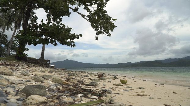 Wild beautiful beach with sand and coconut palms. Tropical bay in El Nido. Sky and mountains rocks. . Seascape: mountains, ocean., beach. Philippines, El Nido Travel concept