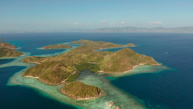aerial view tropical islands with blue lagoon, coral reef and sandy beach. Palawan, Philippines. Islands of the Malayan archipelago with turquoise lagoons.