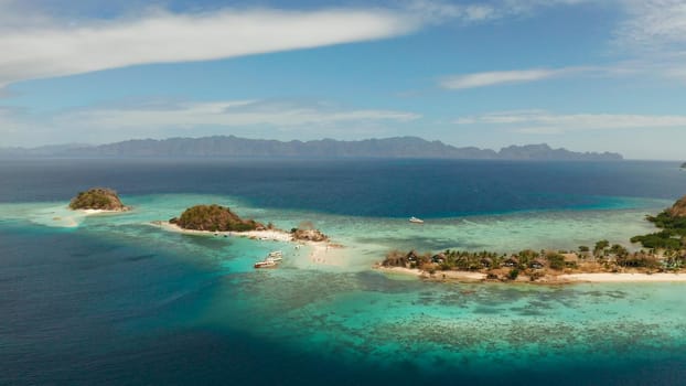aerial seascape island with white beach. Bulog Dos, Philippines, Palawan. tourist boats on coast tropical island. Seascape bay with turquoise water and coral reef.