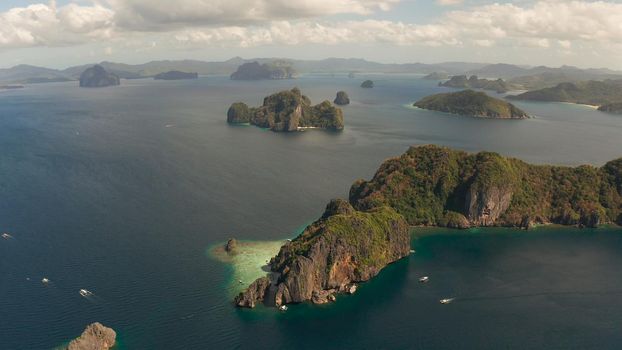 Cove with lagoons and the tropical islands, aerial view. Seascape with tropical rocky islands, ocean blue water. islands and mountains covered with tropical forest. El nido, Philippines, Palawan. Tropical Mountain Range