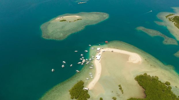 Beautiful beach on tropical island surrounded by coral reef, sandy bar with tourists. honda bay top view. Luli island. Summer and travel vacation concept, Philippines, Palawan