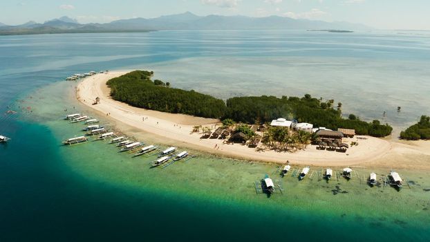 Beautiful beach on tropical island surrounded by coral reef, sandy bar with tourists. honda bay top view. Starfish island. Summer and travel vacation concept, Philippines, Palawan