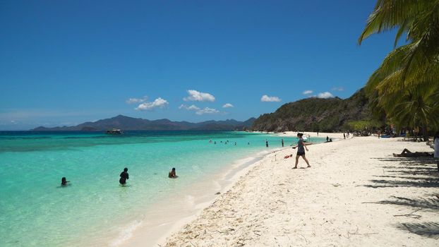 Tropical beach on the island Malcapuya, Palawan, Philippines. Beautiful tropical island with sand beach, palm trees. Tropical landscape: beach with palm trees. Seascape: Ocean, sky, sea. Travel concept