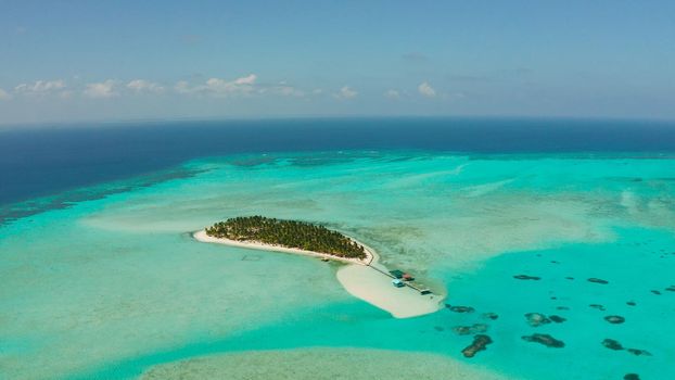 Tropical island among coral reefs with a white beach and blue atoll water. Onok Island, Balabac, Philippines. Summer and travel vacation concept