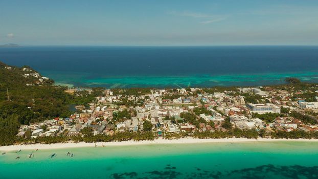 Tropical lagoon with turquoise water and white sand beach Boracay, Philippines. White beach with tourists and hotels. Tropical white beach with sailing boat.
