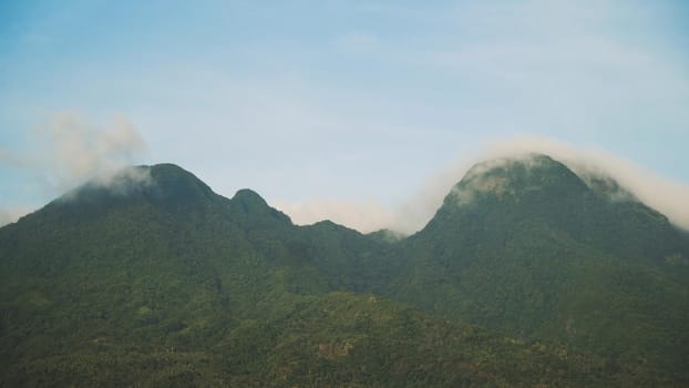 Mountains landscape, rainforest, jungle, blue sky, clouds and mist. Volcano on the island of Camiguin. Travel concept.