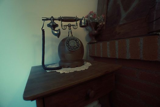 Antique fixed telephone with earphone and made of wood