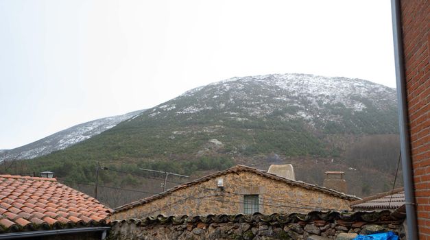 Roof of an old house with foggy mountain in the background.