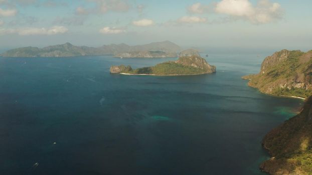 Seascape with tropical bay, rocky islands, ocean blue water, aerial view. islands and mountains covered with tropical forest. El nido, Philippines, Palawan. Tropical Mountain Range