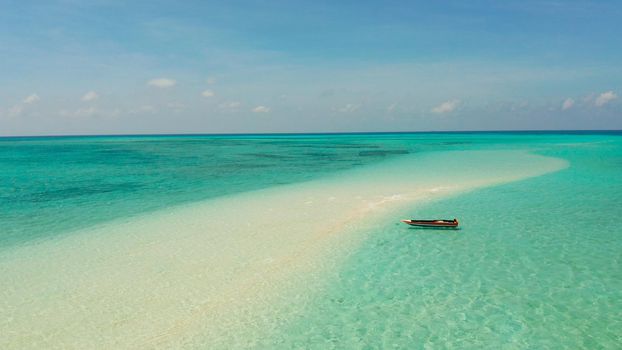 Sandy beach with tourists among turquoise waters and coral reefs. Mansalangan sandbar. Beach at the atoll. Summer and travel vacation concept. Balabac, Palawan, Philippines.
