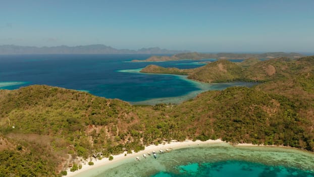 aerial view tropical island Bulalacao with blue lagoon, coral reef and sandy beach. Palawan, Philippines. Islands of the Malayan archipelago with turquoise lagoons.