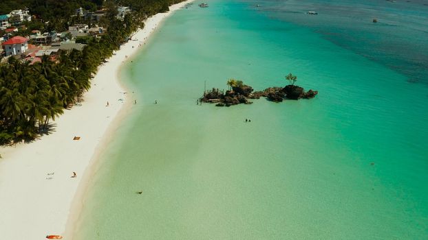 White sand beach and Willy's rock with tourists and hotels and sailing boat, aerial view. Boracay, Philippines. Summer and travel vacation concept.