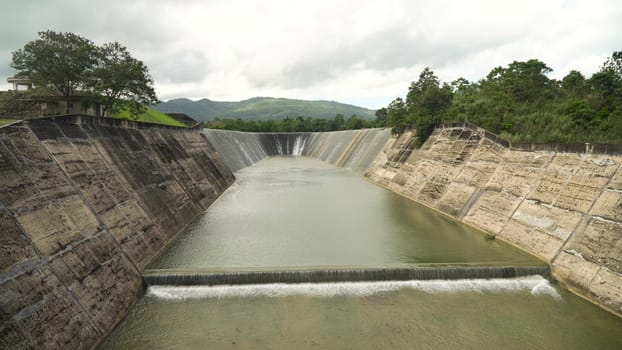 Dam on the lake in the rainforest on the island. Water flowing from the dam, Water for Irrigation countryside. Water Cascades Over Lake Bohol island, Philippines. .