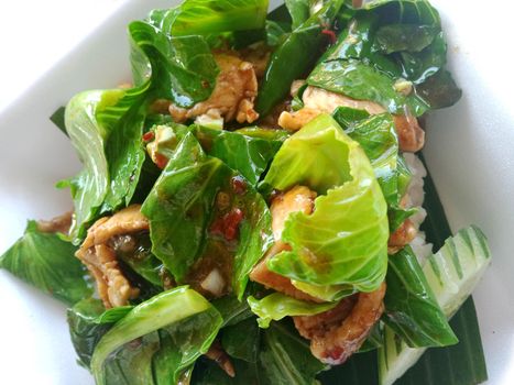 Stir fried 3 layers of pork kale on top of cooked rice.