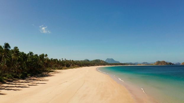 Blue sea and tropical beach, aerial drone. Nacpan, El Nido, Palawan, Philippine Islands. Seascape with tropical beach and islands. Summer and travel vacation concept