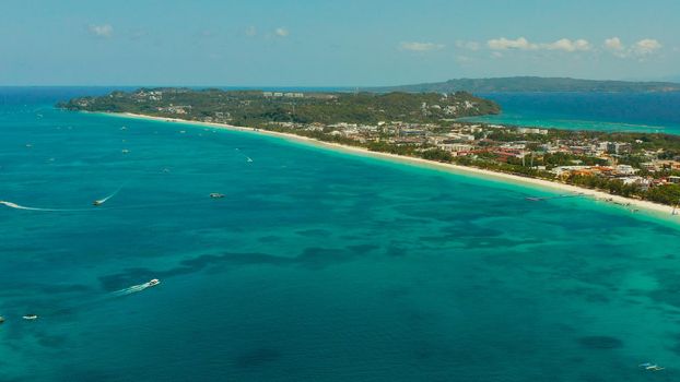 Tropical white beach with tourists and hotels near the blue sea, aerial view. Summer and travel vacation concept.