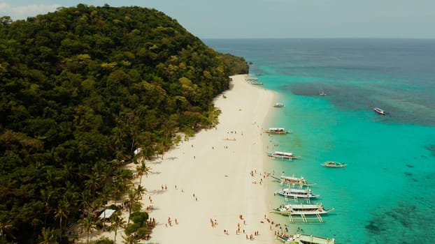 Aerial seascape: Tropical beach with palm trees and turquoise waters of the coral reef, from above, Puka shell beach. Boracay, Philippines. Seascape with beach on tropical island. Summer and travel vacation concept.
