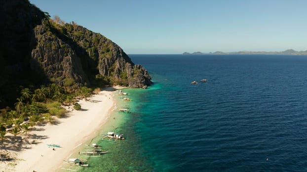 aerial drone tropical island and sand beach with palm trees. Malajon Island, Philippines, Palawan. tourist boats on coast tropical island. Summer and travel vacation concept. beach and blue clear sea water
