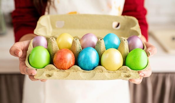 Woman hands holding pack of colorful easter eggs