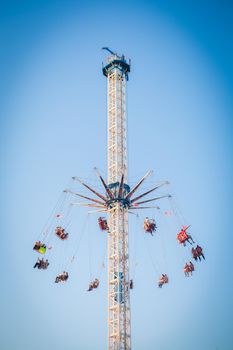 People have fun enjoying the air carousel in the amusement park.