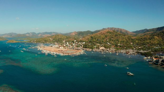 aerial view Coron City, tourist destination in the Philippines.Pier and promenade Coron town with boats on Busuanga island. Wooden boats waiting at pier. Seascape with mountains. Philippines, Palawan