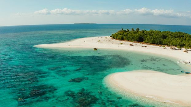 Aerial view of sandy beach on a tropical island with palm trees by coral reef atoll. Patawan island with sandy beach. Summer and travel vacation concept.