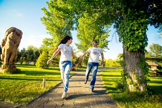 Young romantic couple have fun enjoy each other in green summer park.