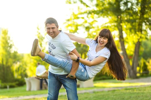 Young romantic couple have fun enjoy each other in green summer park.