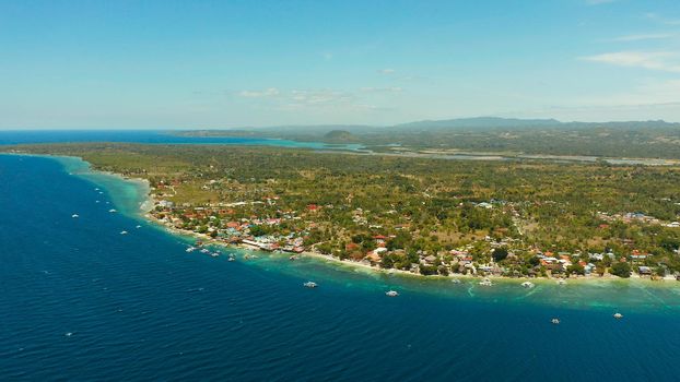 Shore with hotels near coral reef and diving boats, Moalboal, Philippines. Aerial view, Summer and travel vacation concept.