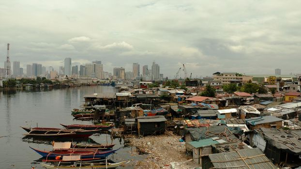 Shacks in the slums of Manila in a poor district and skyscrapers of a big city, aerial view.