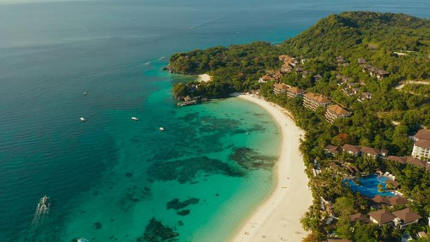 Tropical lagoon with turquoise water and white sand beach Boracay, Philippines. White beach with tourists and hotels. Tropical white beach with sailing boat.