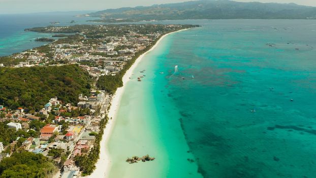 Tropical lagoon with turquoise water and white sand beach Boracay, Philippines. White beach with tourists and hotels. Tropical white beach with sailing boat.