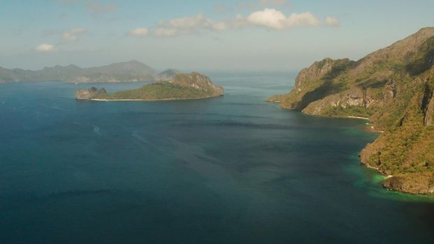 Seascape with tropical bay, rocky islands, ocean blue water, aerial view. islands and mountains covered with tropical forest. El nido, Philippines, Palawan. Tropical Mountain Range