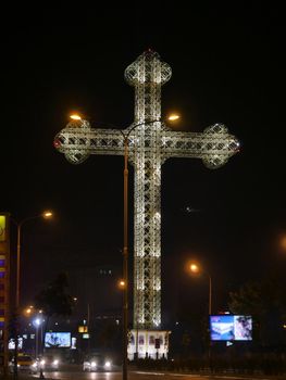 Orthodox cross light in night at city