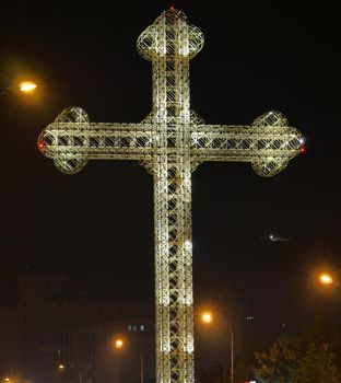 Orthodox cross light in night at city