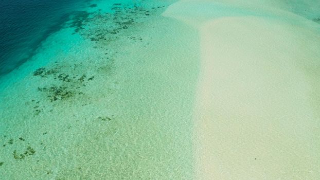 White sandy beach in the lagoon with turquoise water on a tropical island. Mansalangan sandbar. Beach at the atoll. Summer and travel vacation concept. Balabac, Palawan, Philippines.