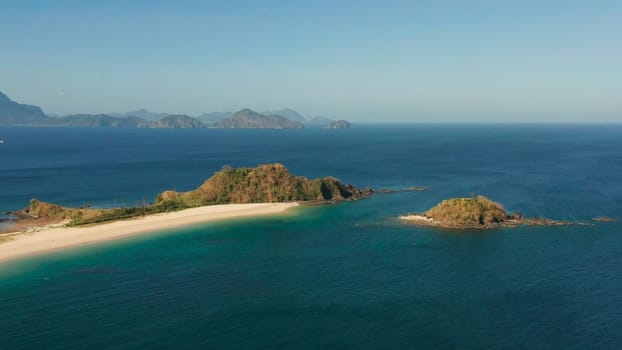 Blue sea and tropical beach, aerial drone. Nacpan, El Nido, Palawan, Philippine Islands. Seascape with tropical beach and islands. Summer and travel vacation concept
