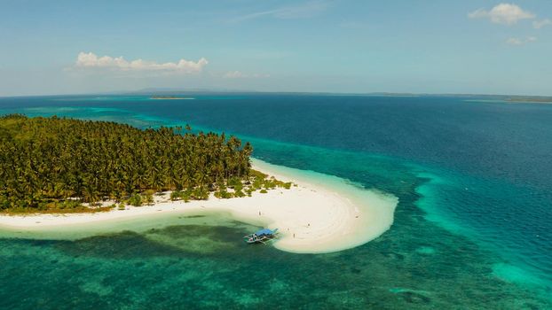 Tropical island with sandy beach by atoll with coral reef and blue sea, aerial view. Patongong Island with sandy beach. Summer and travel vacation concept.