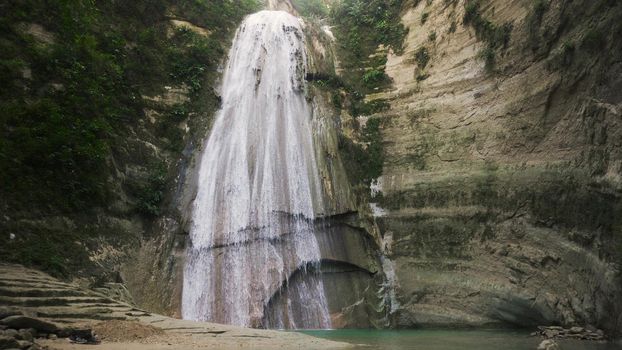 Waterfall in green forest in jungle. Beautiful waterfall in the mountains. Tropical rain forest with waterfall. Philippines, Cebu. Travel concept.