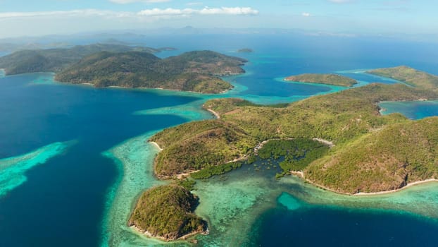 aerial view tropical islands with blue lagoons, coral reef and sandy beach. Palawan, Philippines. Islands of the Malayan archipelago with turquoise lagoons.
