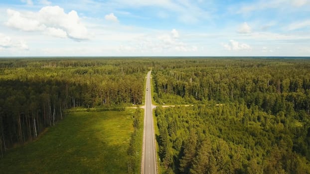 Highway among the green woods in the countryside. Aerial view Road through the green forest.